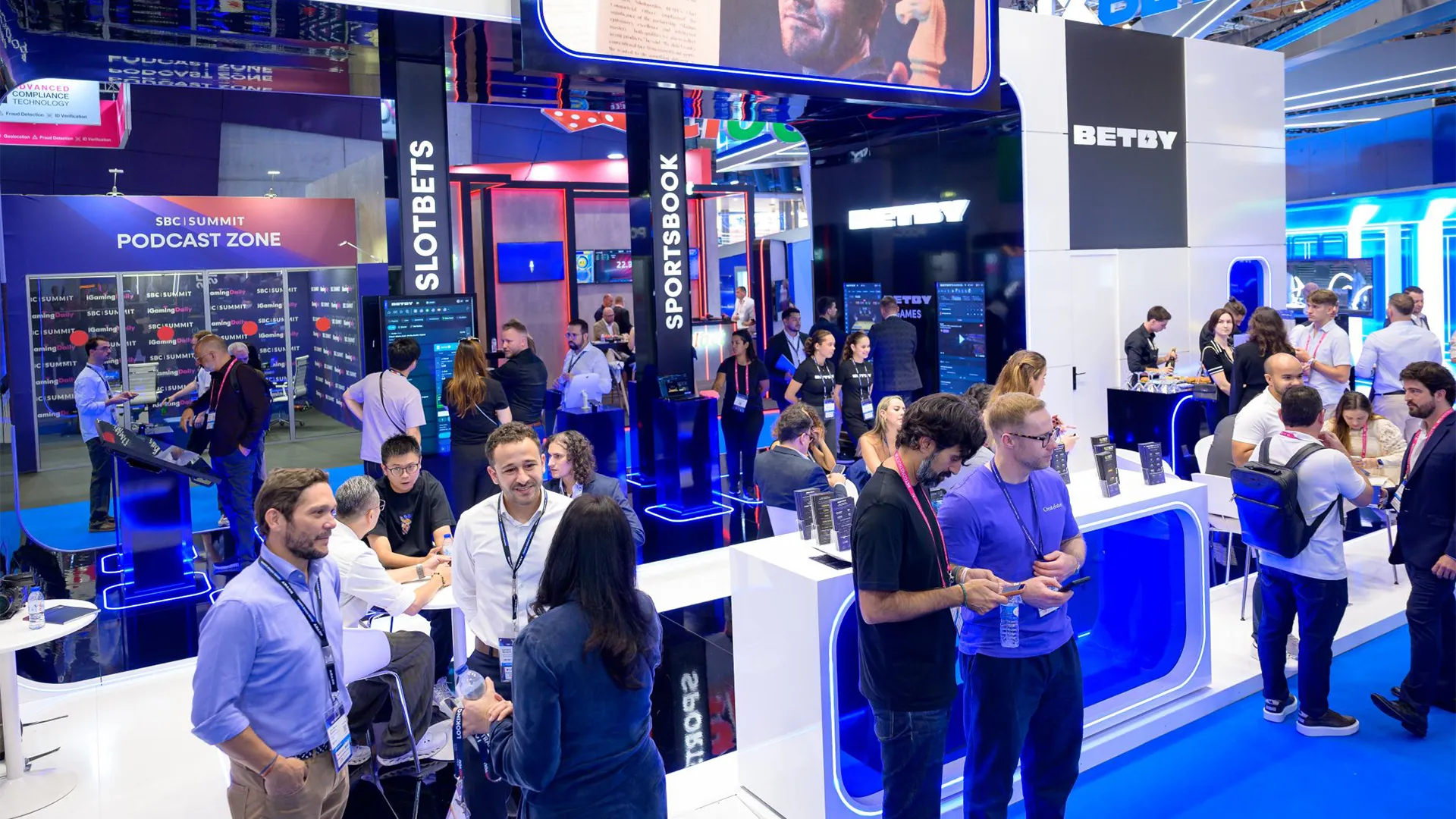 Visitors meeting at tables and exploring product displays on the BETBY stand at SBC Summit Lisbon 2026.