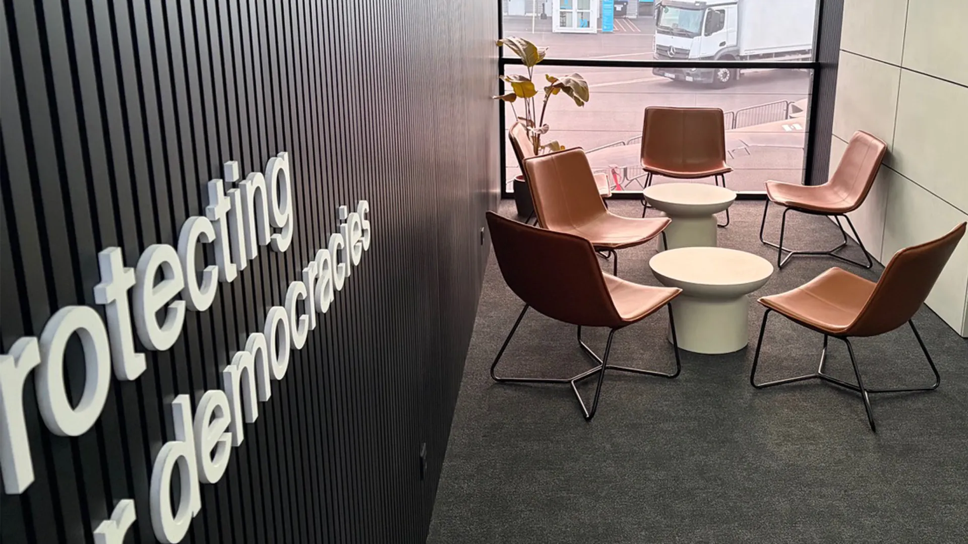 Private lounge inside Helsing’s ILA Berlin chalet with leather seating and “Protecting our democracies” wall signage