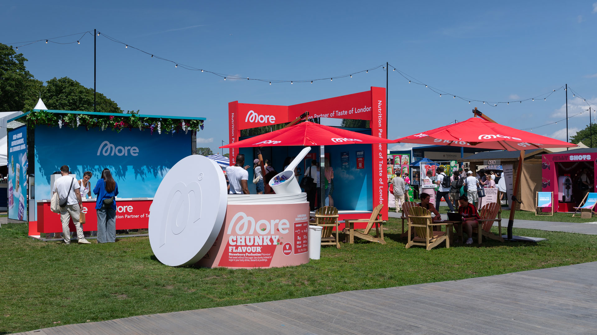 Wide view of More Nutrition outdoor activation at Taste of London with branded sampling areas and seating