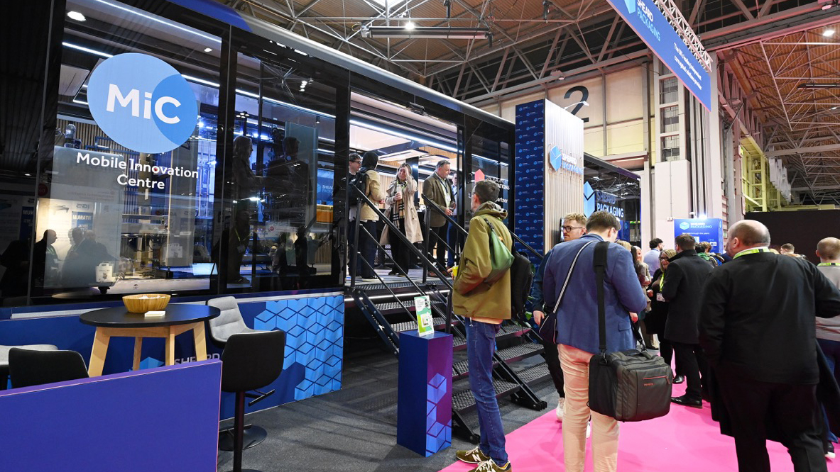 Visitors gather outside Sheard Packaging’s MiC Mobile Innovation Centre at Packaging Innovations and Empack 2026, showcasing the award winning exhibition stand by Equinox Group